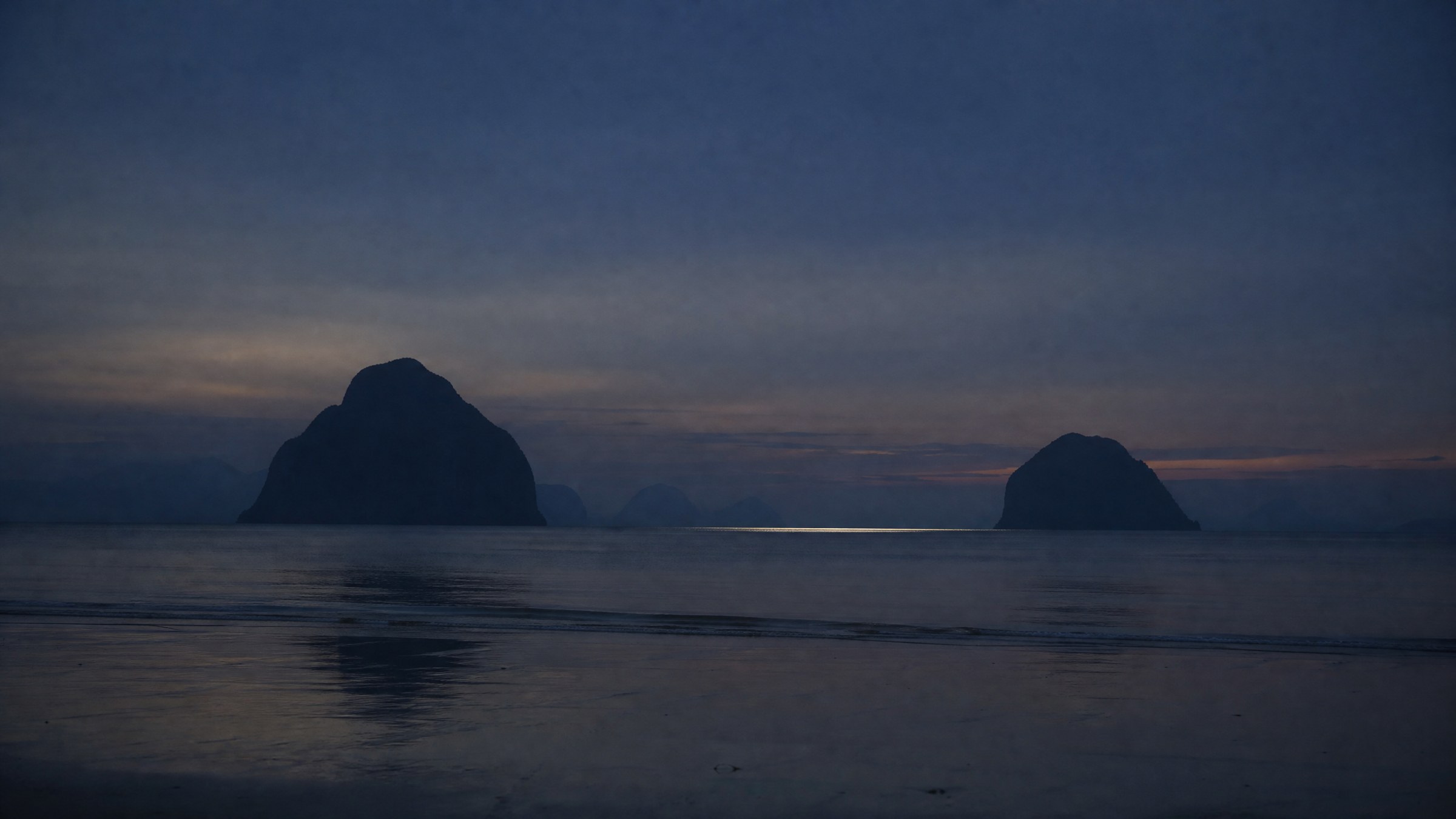 The sea off Lio at dusk, the karst islands going flat and blue on the horizon.