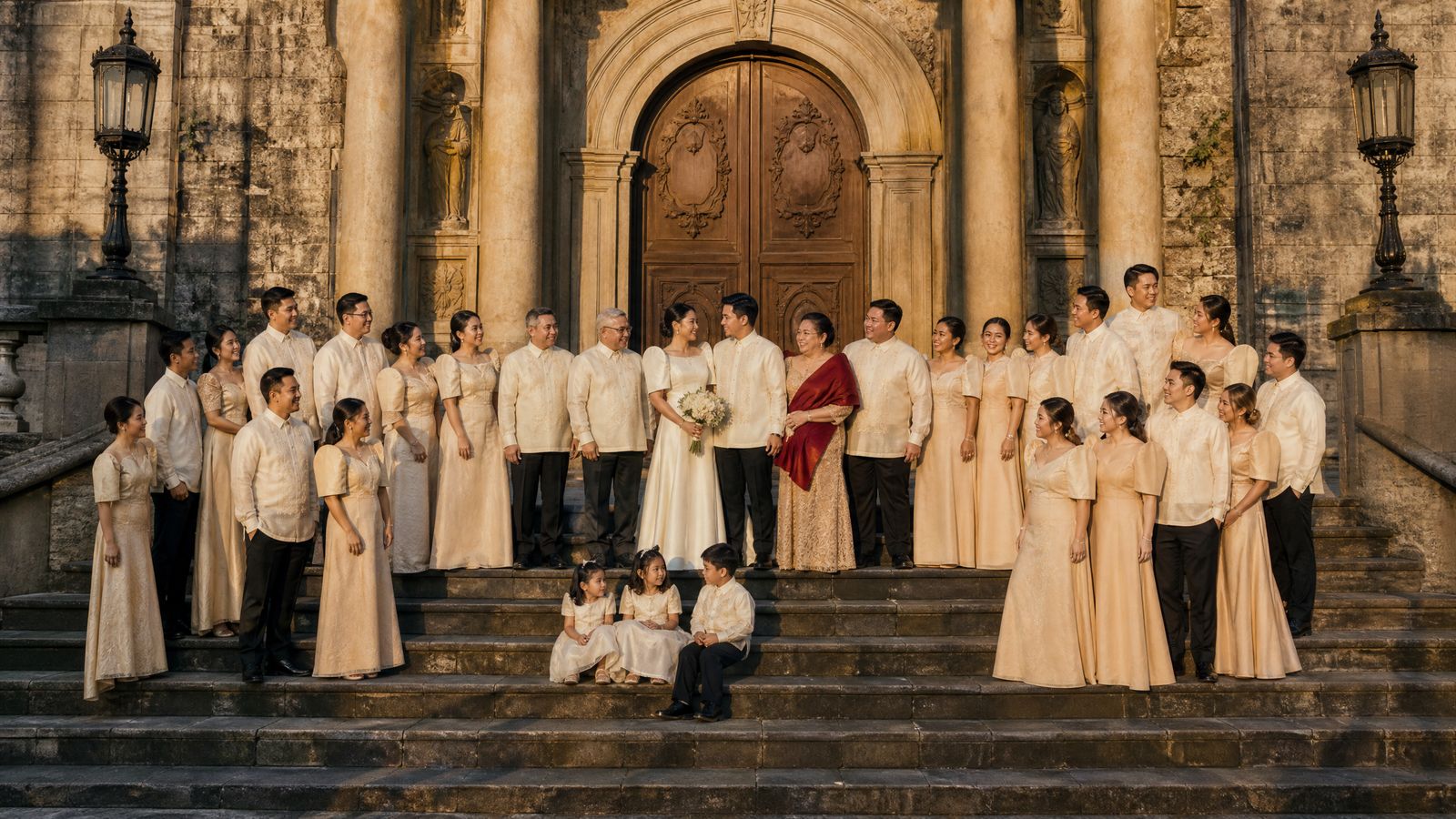 The whole wedding party ranged across the wide stone steps of San Agustin in late-afternoon sun, the couple together at the centre.