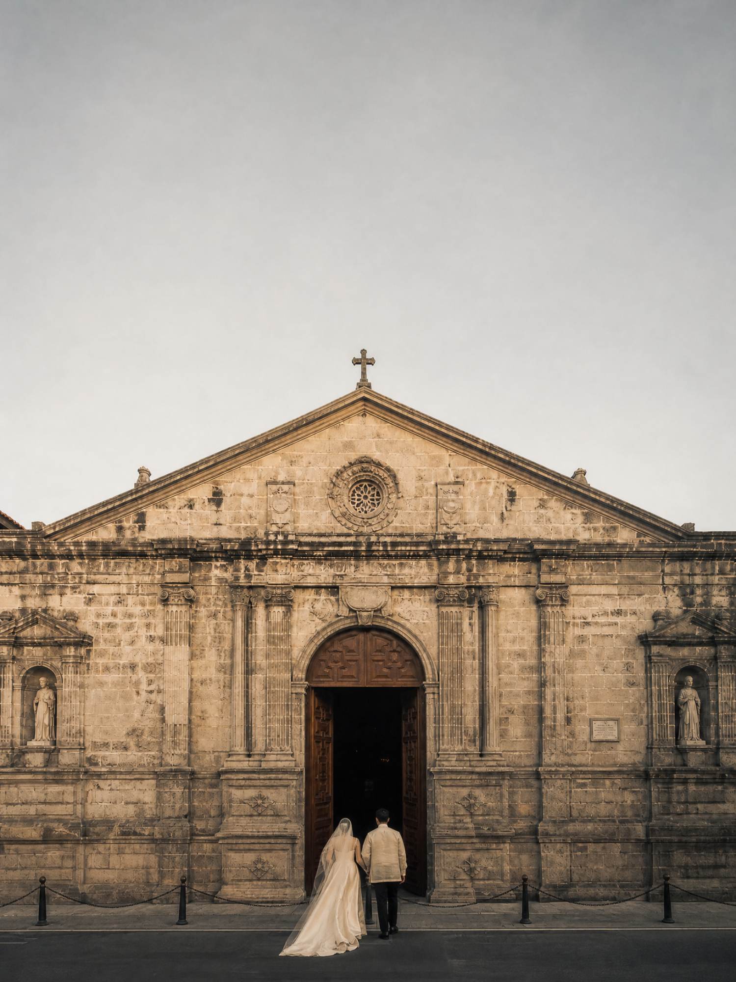 Andrea and Paolo seen from behind, walking into a lit doorway.