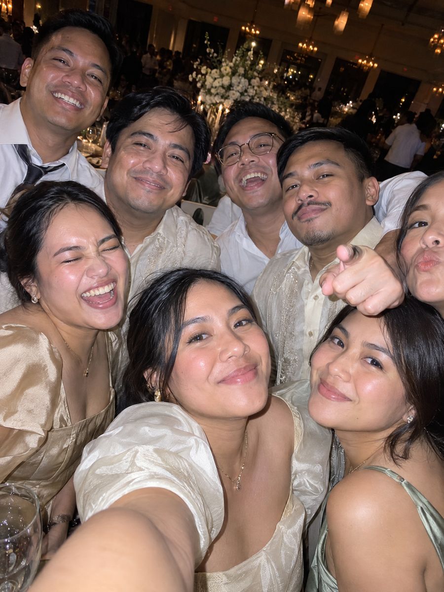 A crowd of cousins in a front-camera flash selfie at the reception.